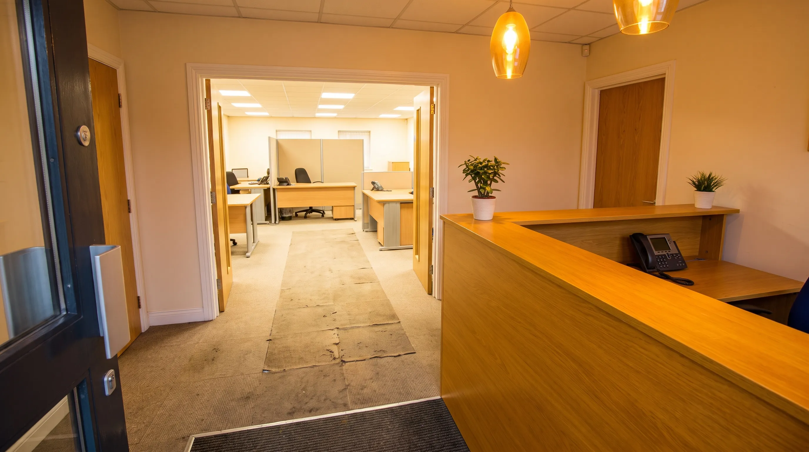 A business reception counter and desk phone show where phone enquiries enter the lead-tracking process.