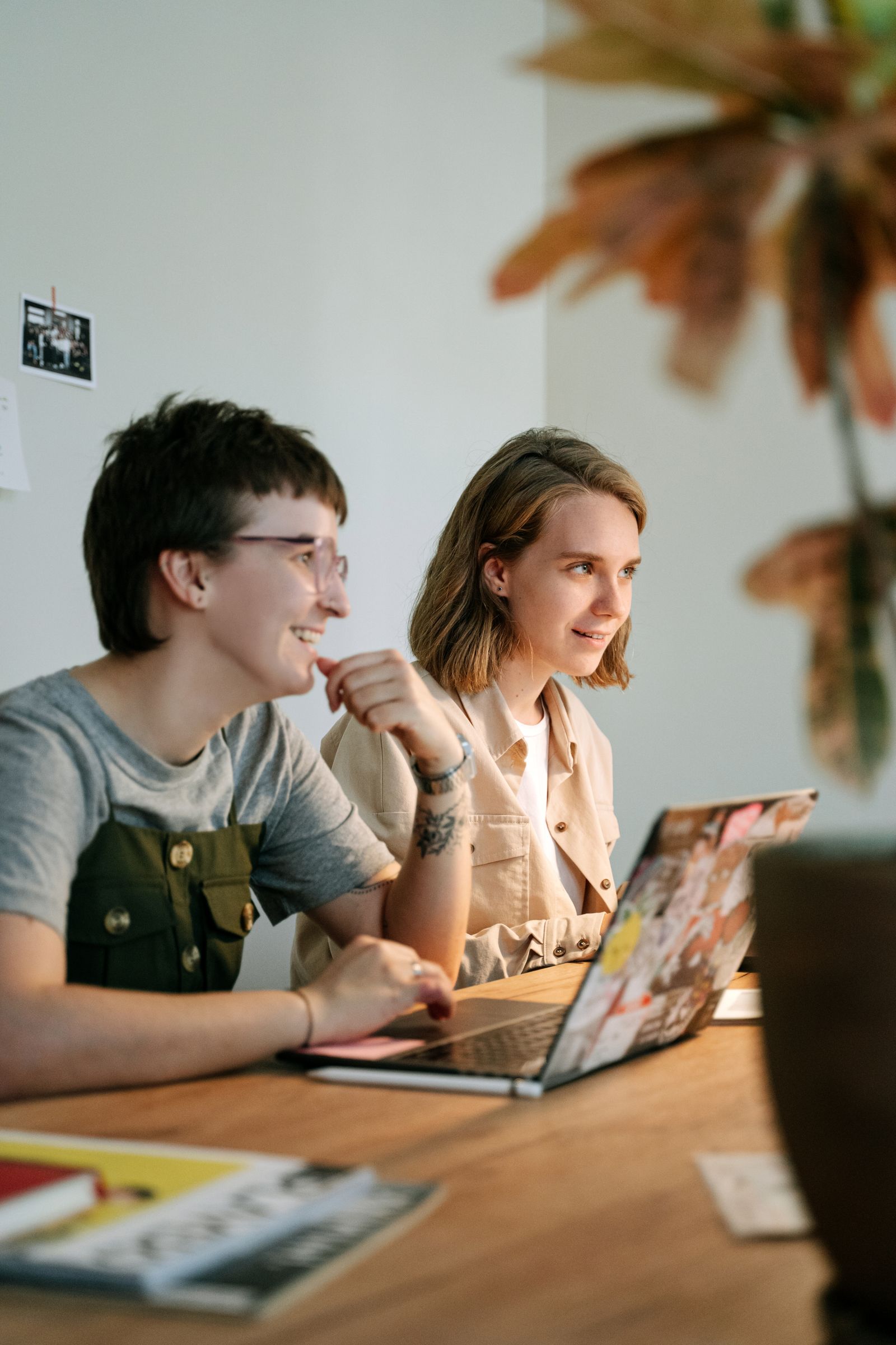 Two colleagues at a shared desk, walking through the week's real work together